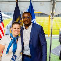 Guests posing together under a tent at the Jamie Hosford Football Center dedication.